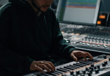 Luminate crea un sistema global para identificar la música generada por IA Manos de un músico tocando un teclado electrónico en un estudio